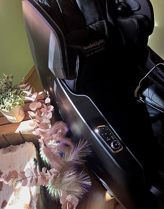 BrainLight massage chair with cozy ambience and natural plant decoration.