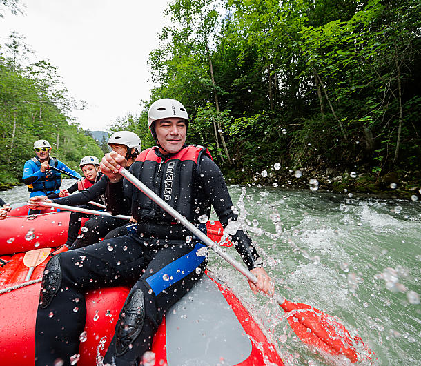 Rafting adventure in Flachau – guests enjoying a wild water tour with lots of fun and splashes in the Alps.