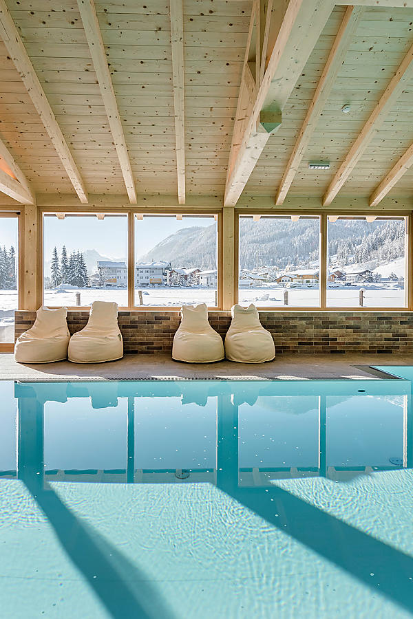 Indoor pool with panoramic mountain view at the almlust wellness area in Flachau