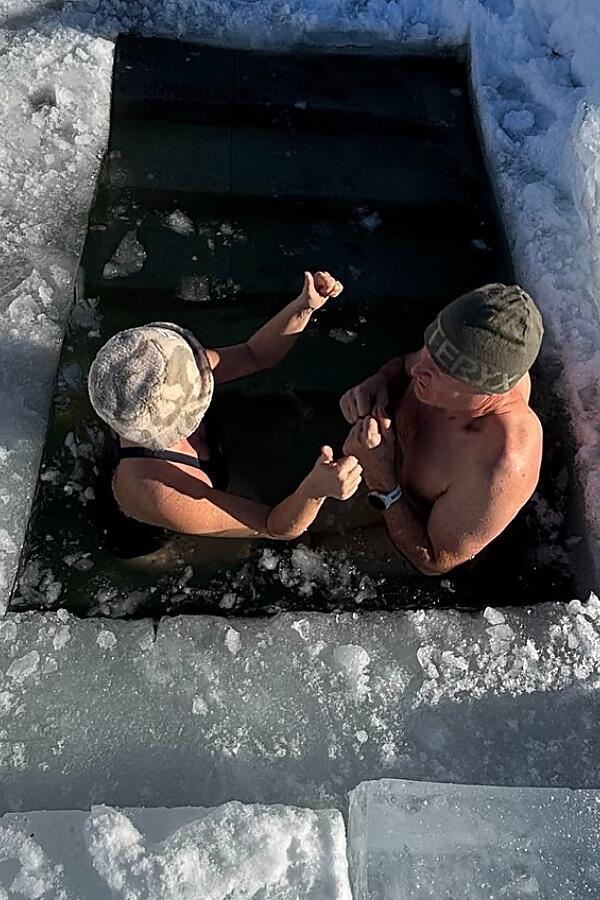 Ice bathing in the natural lake – Retreat highlight in Flachau Two people ice bathing in a frozen natural lake during a retreat in Flachau