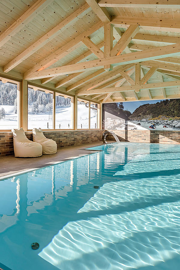 Indoor pool with mountain view – Almlust wellness Sunlit indoor pool with alpine view at Almlust Flachau