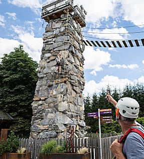 Woman with climbing gear ascending the Almlustrock tower in Flachau