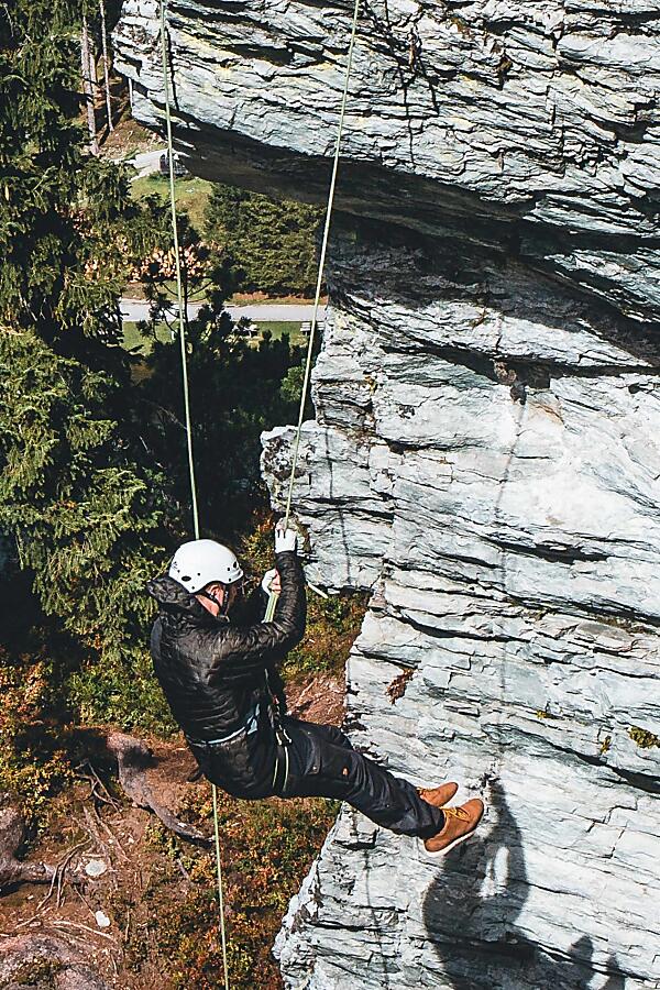 Abseiling on the Via Ferrata – Adventure in Flachau Person abseiling down a rock wall on the via ferrata in Flachau
