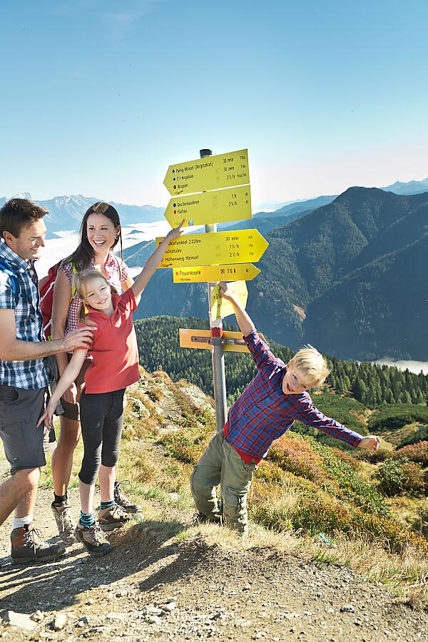 Familienwanderung Flachau mit Aussicht – Wegweiser am Berg Wanderfamilie vor Wegweisern in den Bergen von Flachau – perfekter Start für Familienwanderungen im SalzburgerLand