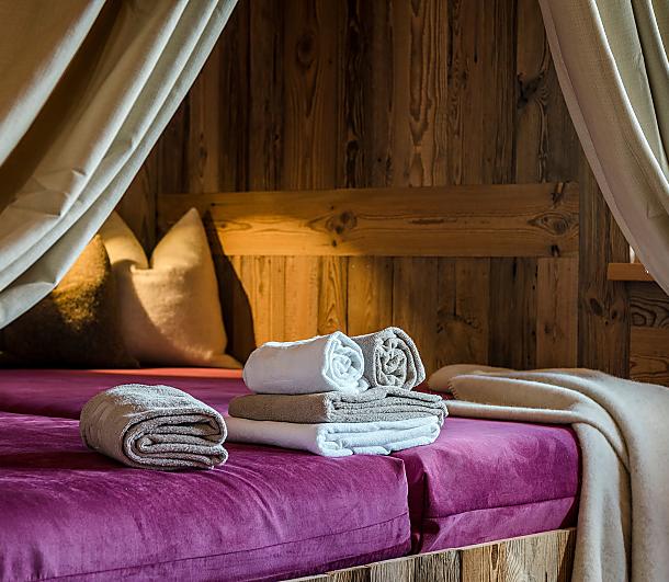 Gemütliche Kuschelecke mit Vorhängen und Handtüchern im Private Spa der Almlust