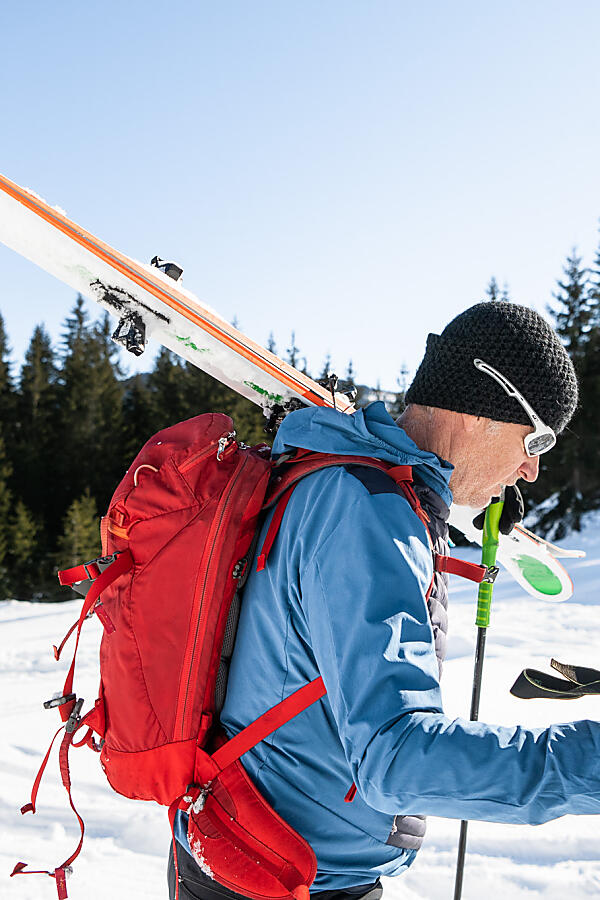 Ski tourer carrying skis during ascent near Flachau