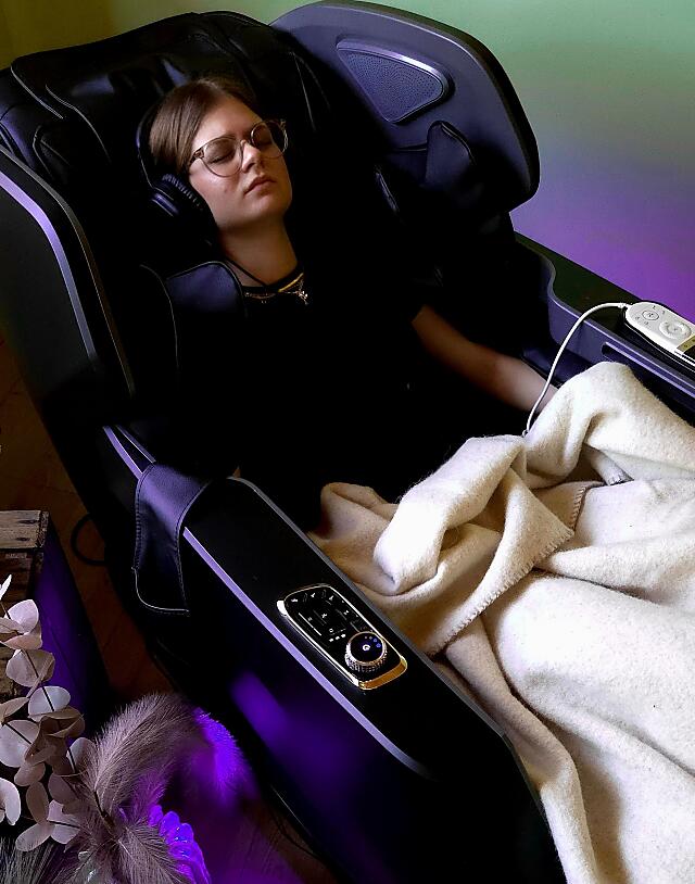Guest relaxing in a brainlight relaxation chair at the Alm Spa at almlust in Flachau