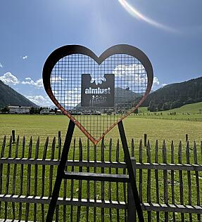 Herzförmige Love Wall am Almsee der almlust mit Blick auf Wiese, Berge und Himmel in Flachau