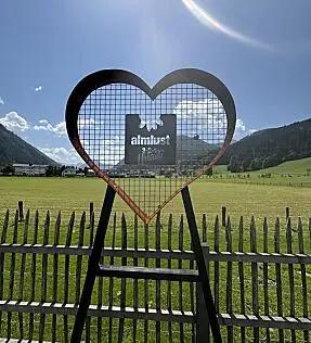 Heart-shaped Love Wall by the Almsee at almlust with meadow, mountains and sky in Flachau