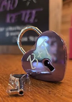 Purple love lock with keys on a wooden table at almlust