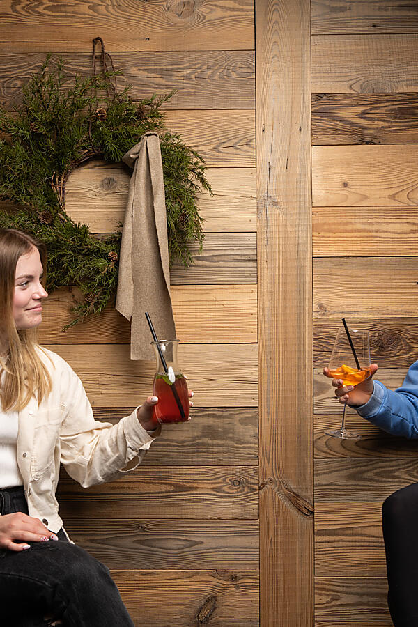Zwei Frauen sitzen in der almlust Lobby und unterhalten sich in entspannter Atmosphäre bei einem Getränk