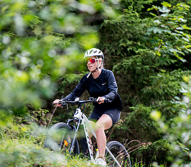 E-Mountainbikerin auf dem Waldweg unterwegs