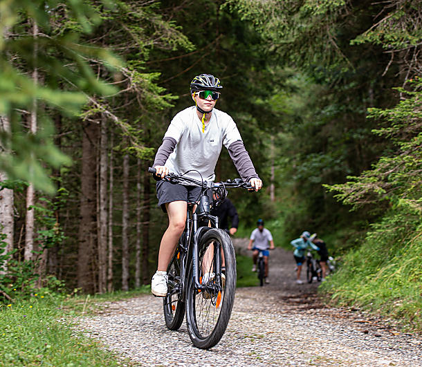 Mountainbiker genießt die Familientour auf einem Waldweg