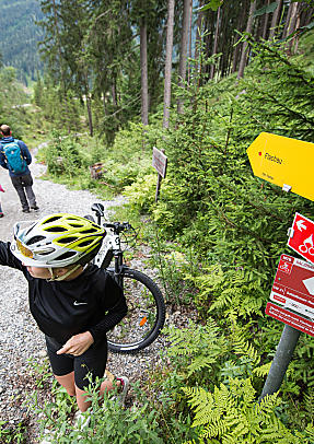 Bikerin schießt ein Selfie mit der Wegbeschreibung 