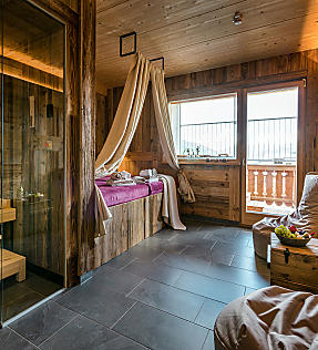 Cozy spa suite with sauna, lounger and balcony view at Almlust